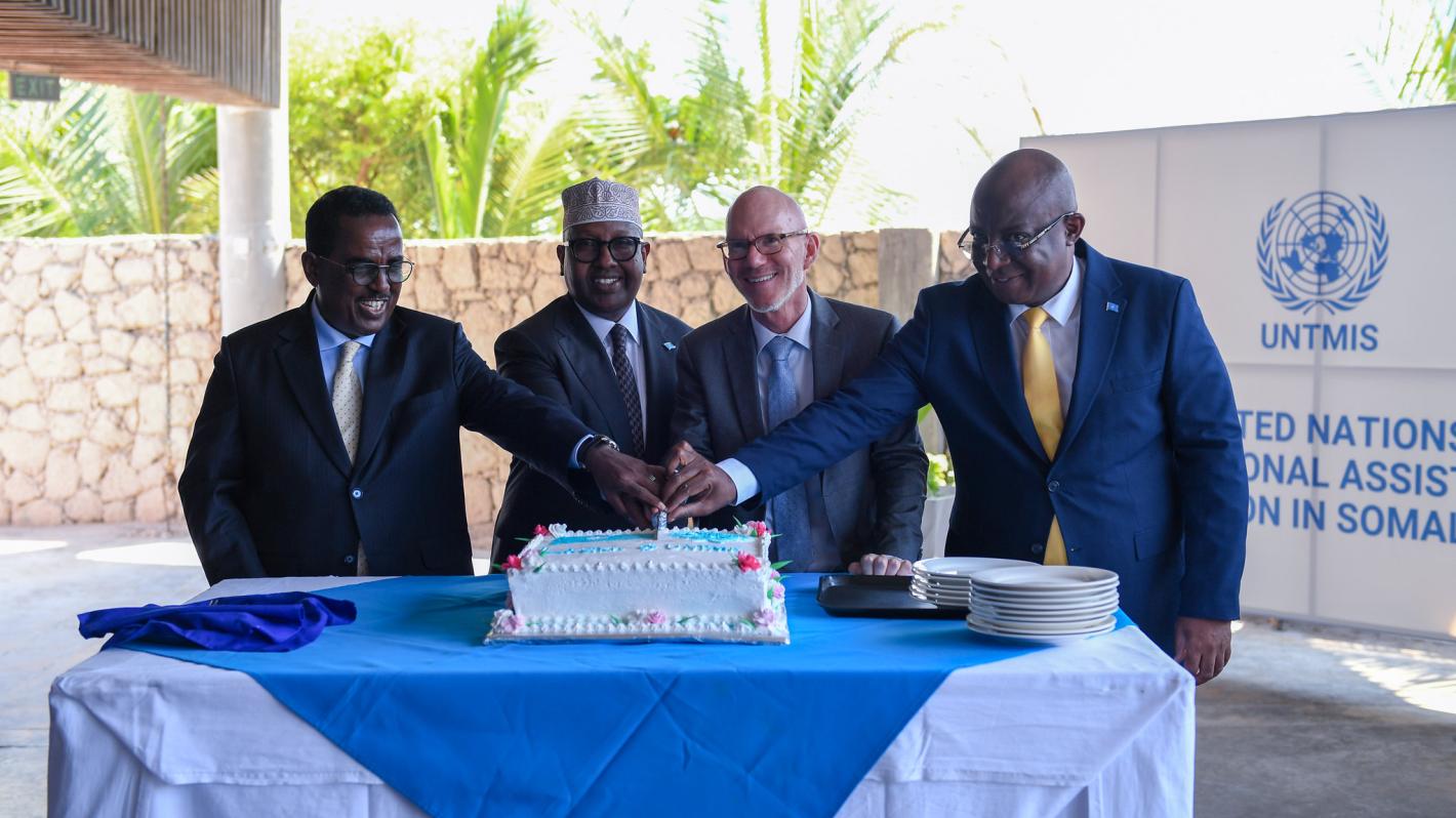 A photo of UN Special Representative James Swan with Somali ministers cutting a cake at the official launch of UNTMIS