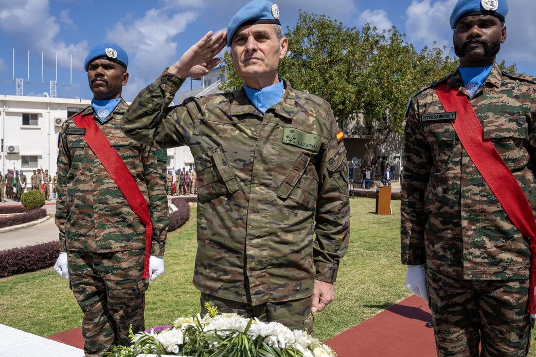 Lieutenant General Aroldo Lázaro salutes with two peacekeepers.